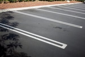 A view of a newly paved parking featuring empty parking stalls.